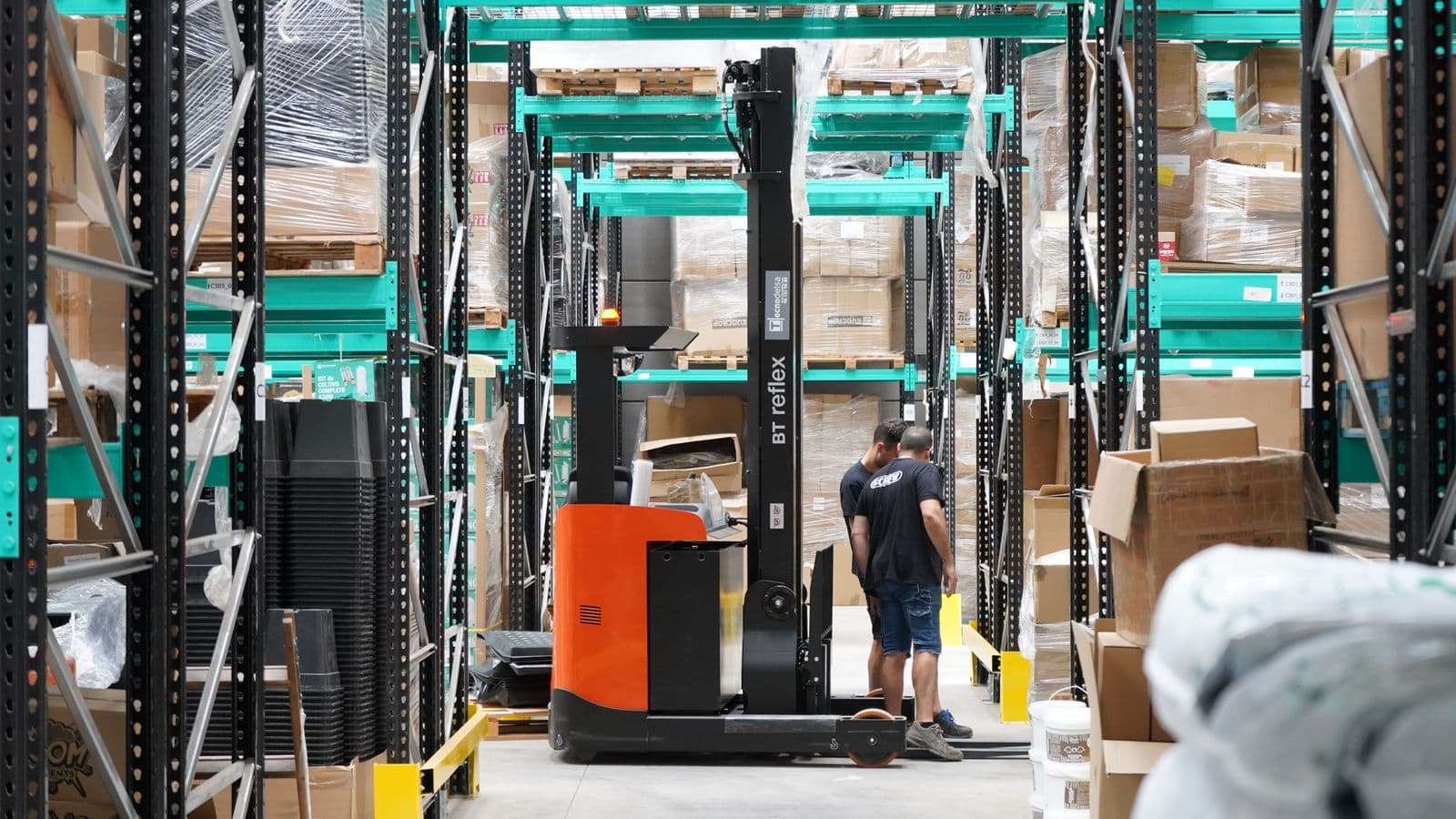 Modern warehouse floor with employees and a forklift in operation