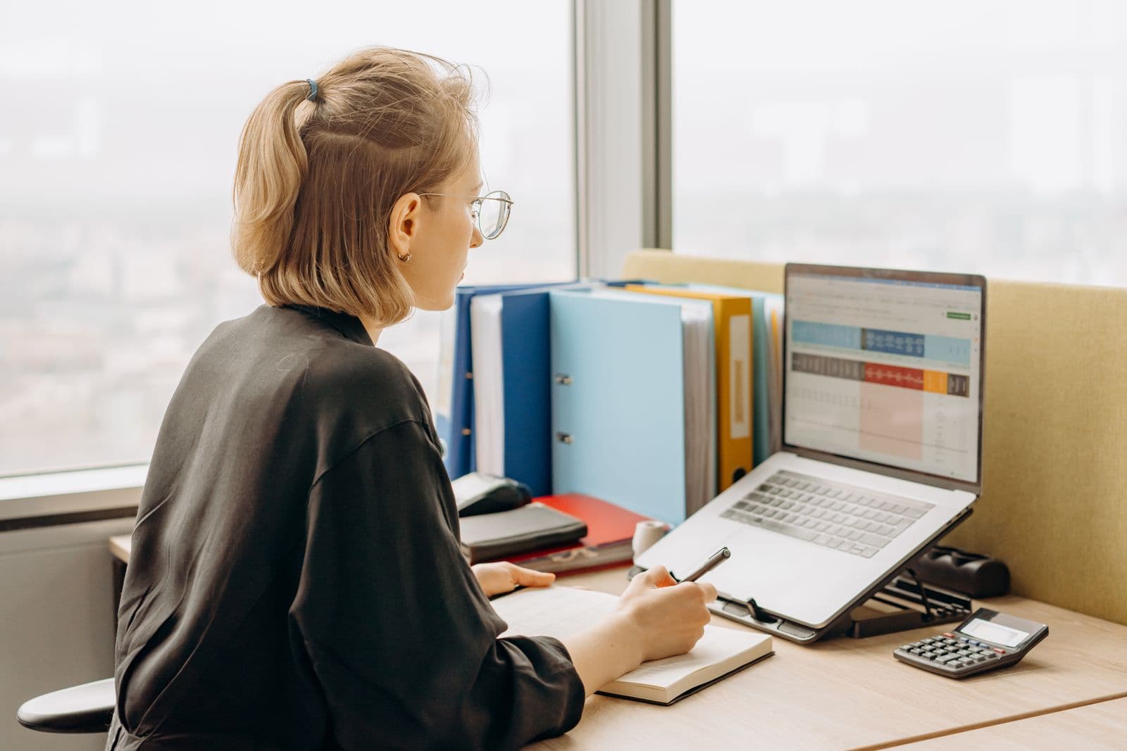 Professional working on a laptop reviewing spreadsheets